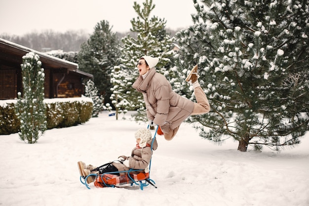 Woman and little girl in a park with a sled