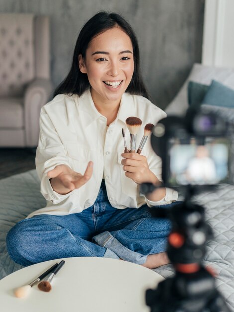 Woman live streaming about make up tools with her camera