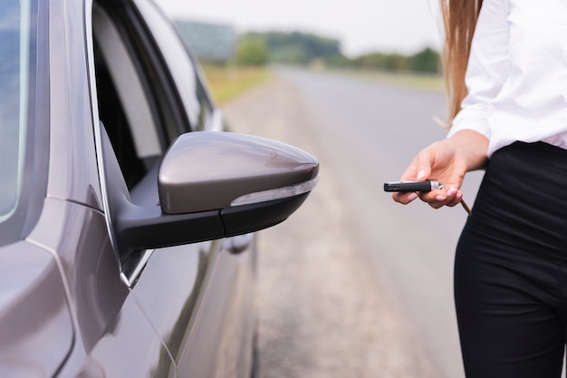 Foto gratuita la donna blocca l'auto sul lato della strada