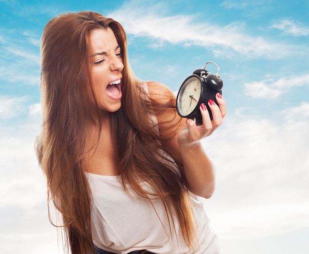 Free photo woman looking at alarm clock