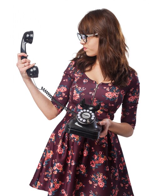 Woman looking at an antique phone