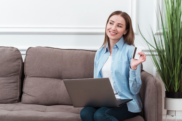 Woman looking away and holding credit card