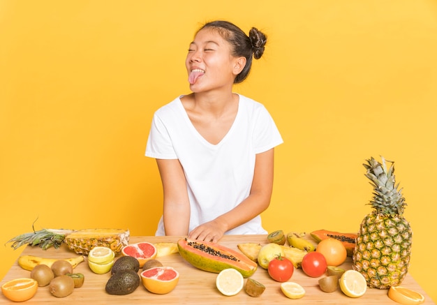 Foto gratuita donna che distoglie lo sguardo dietro una tavola con i frutti