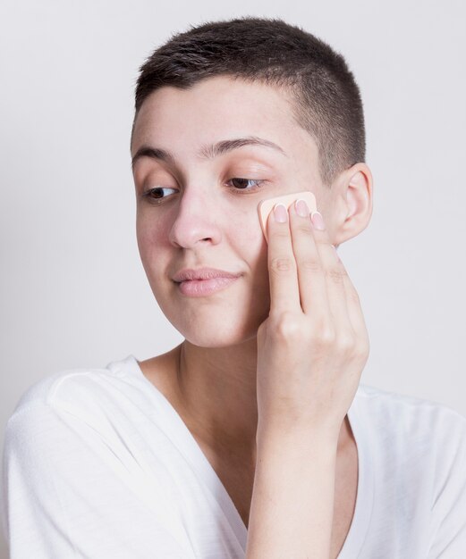 Woman looking away while cleaning face