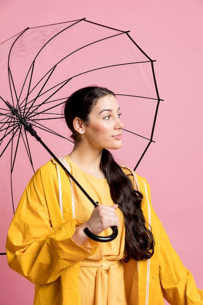 Woman looking away while holding an umbrella