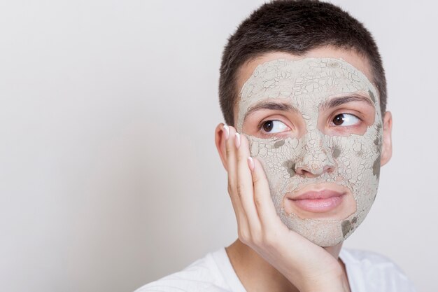 Woman looking away with facial mud treatment