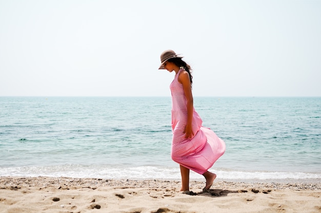 걷는 동안 해변 모래를 바라 보는 여자