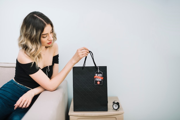 Woman looking at black friday bag with shoppings