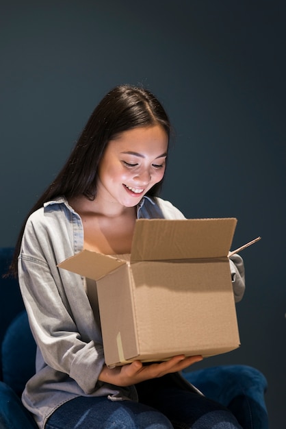 Женщина ищет в коробке после заказа онлайн