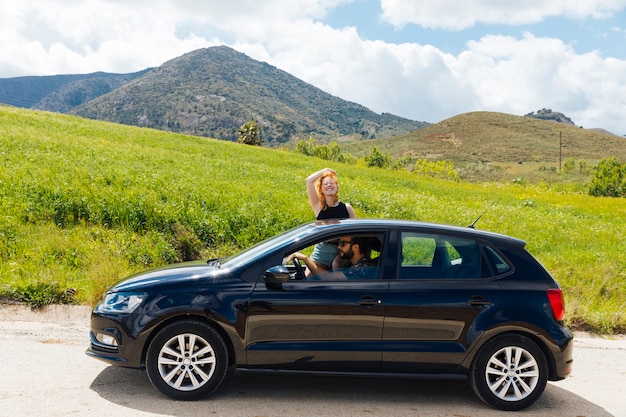 Woman looking at camera getting out of car window 