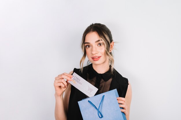 Woman looking at camera holding cyber monday card