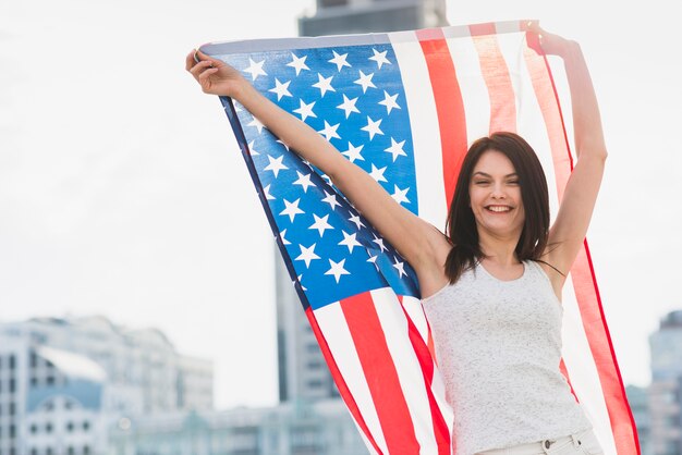 女性のカメラ目線と笑って広いアメリカの国旗