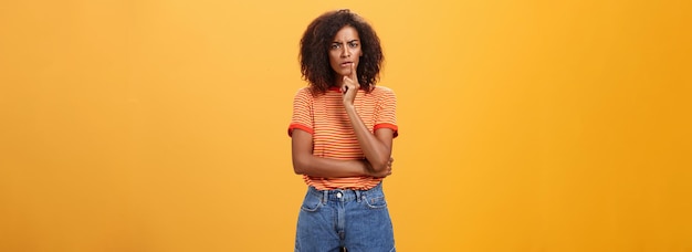 Woman looking concerned picking new furniture in store thoughtful focused and troubled smart african