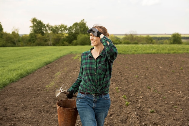 Foto gratuita donna che esamina una terra coltivata