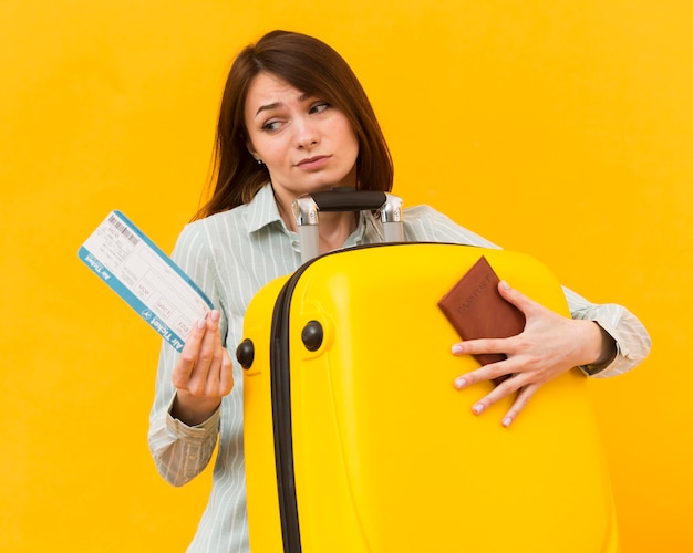 Woman looking disappointed to a plane ticket