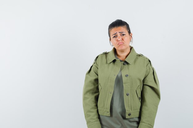 Woman looking at front in jacket, t-shirt and looking humble.