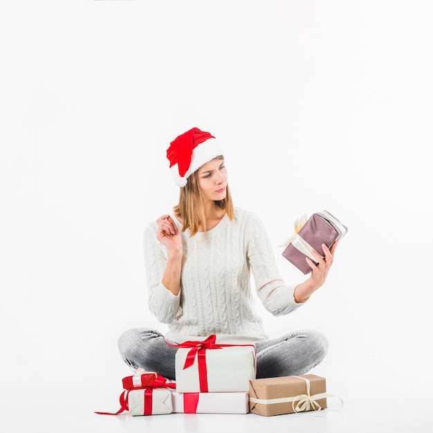 Free photo woman looking at gift box on floor