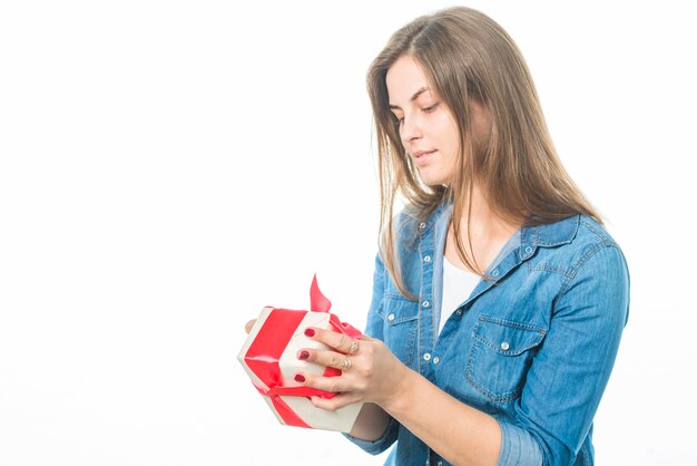 Woman looking at gift on white background