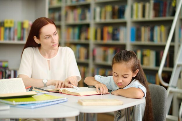 勉強を拒否する女の子を見ている女性