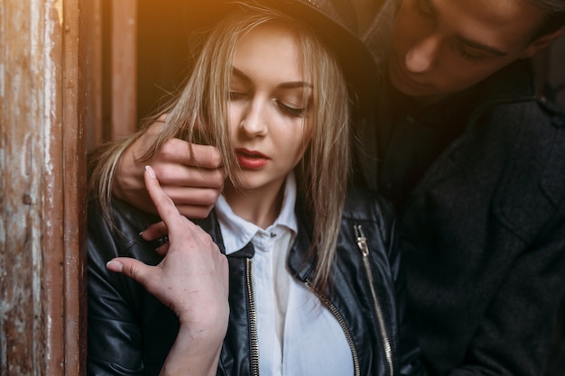 Woman looking at her boyfriend's hand while hugging her