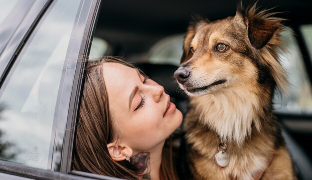 Женщина смотрит на свою собаку в машине