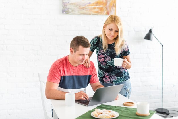 Woman looking at her husband working on laptop