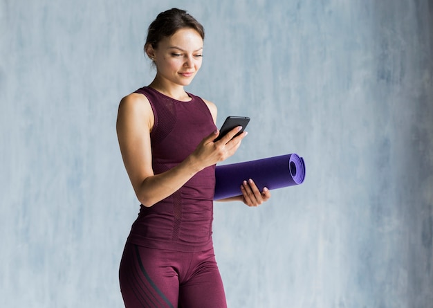 Woman looking at her phone during her training