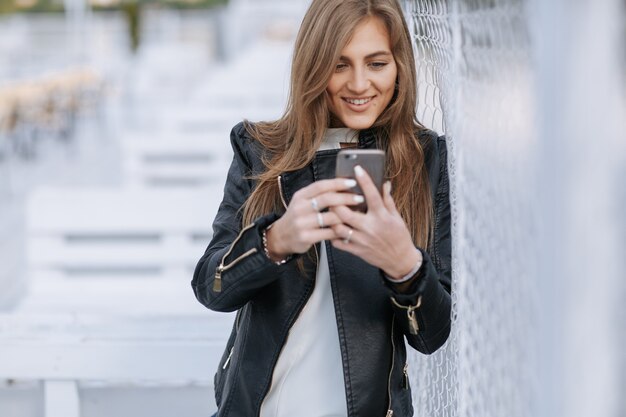 彼女のスマートフォンと笑顔を見ている女性