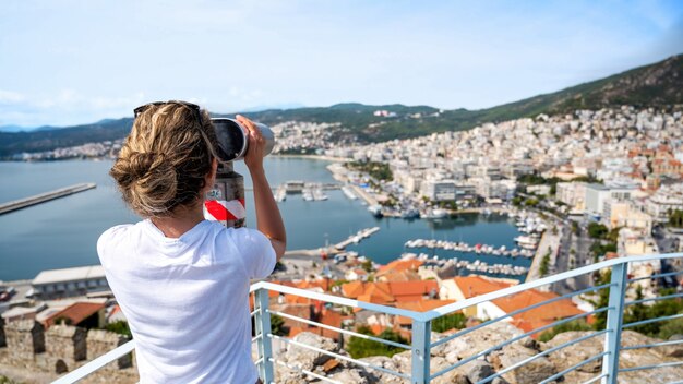 A woman looking into stationary binocular in Kavala, Greece