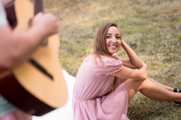 Woman looking at a man playing guitar