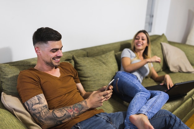 Woman looking at man using mobile phone