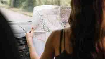 Free photo woman looking at a map in car