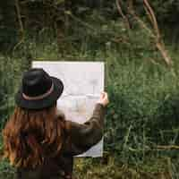 Free photo woman looking at a map in nature