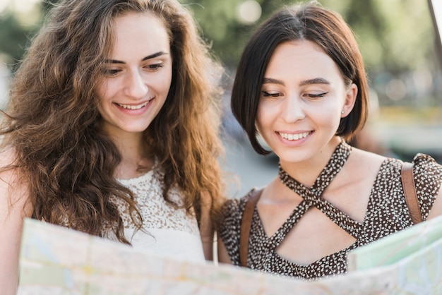 Foto gratuita donna guardando la mappa e sorridente