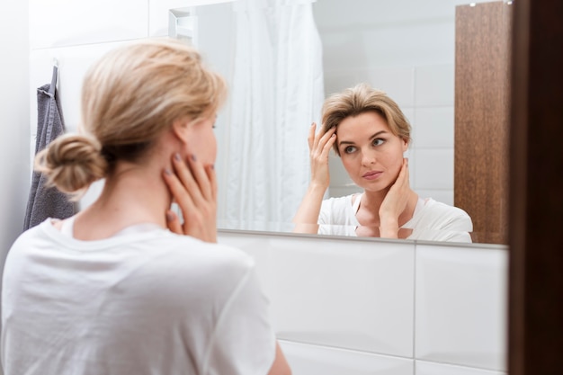 Woman looking in the mirror from behind view