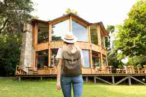 Free photo woman looking at modern house from behind