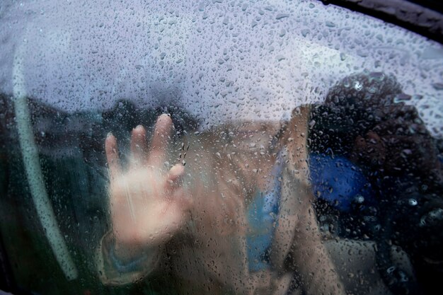 비가 오는 동안 차창 밖을 바라보는 여성