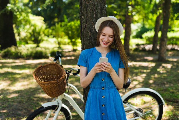 自転車の横にある携帯電話を見ている女性