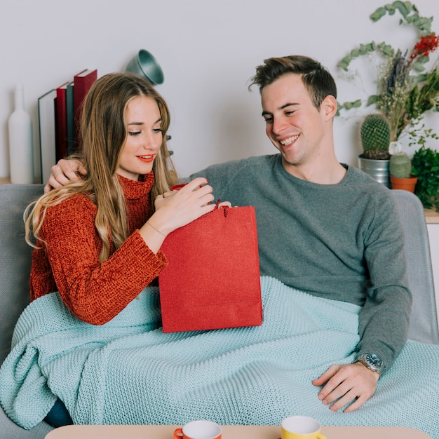 Woman looking at present from man