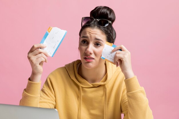 Woman looking sad while holding a teared up plane ticket