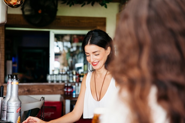 Woman looking to smiling bartender