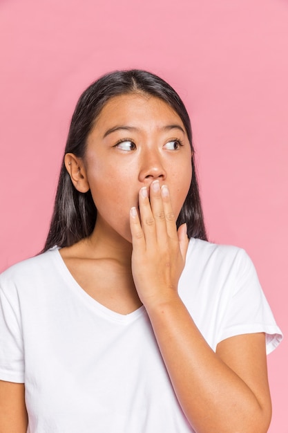 Woman looking surprised with her hand on her mouth