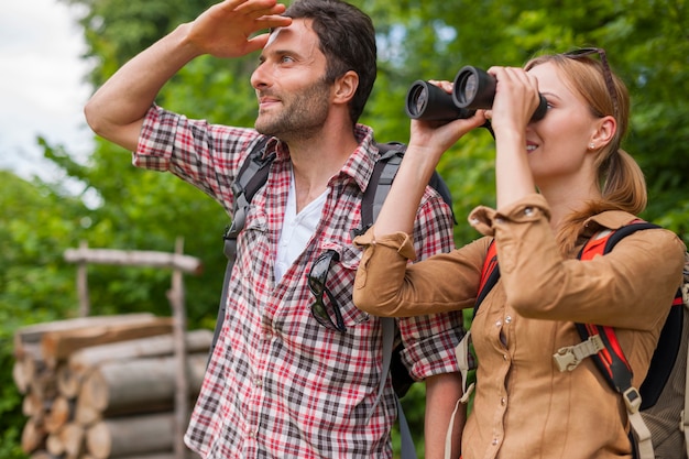 Woman looking through the binoculars. Hiking time