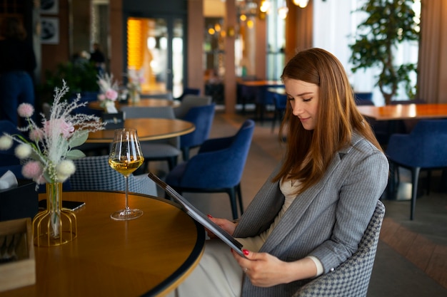 Foto gratuita donna che guarda attraverso il menu del ristorante