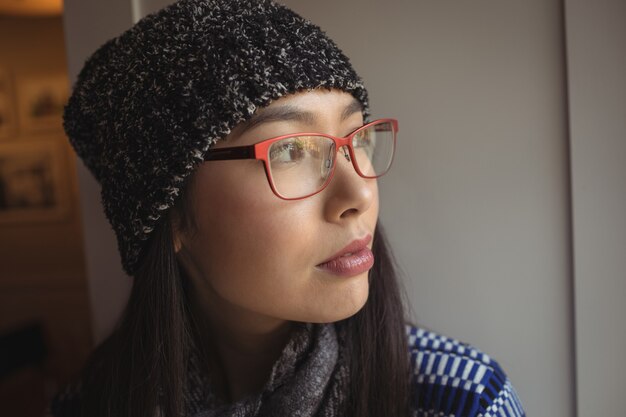 Donna che guarda attraverso la finestra nella caffetteria