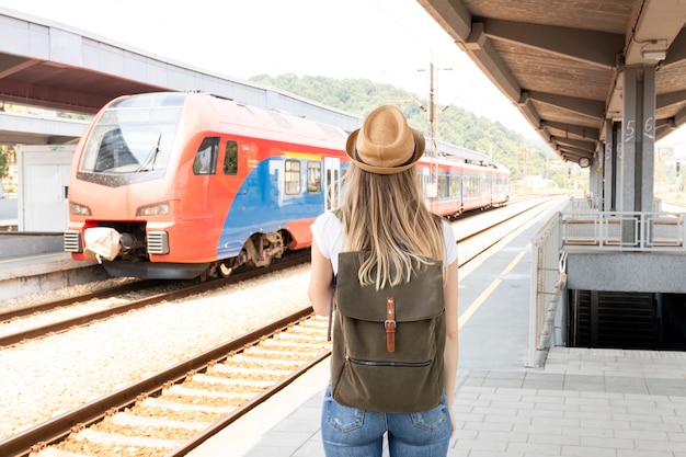 Foto gratuita donna che guarda il treno da dietro