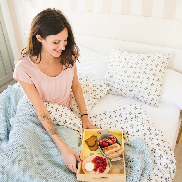 Donna che esamina vassoio con colazione