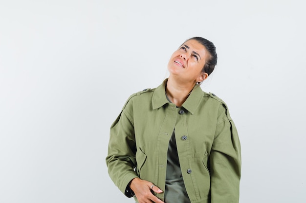 woman looking up in jacket, t-shirt and looking focused