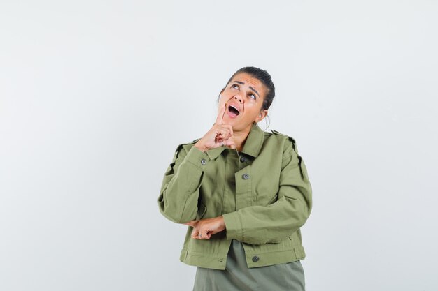 woman looking up in jacket, t-shirt and looking pensive