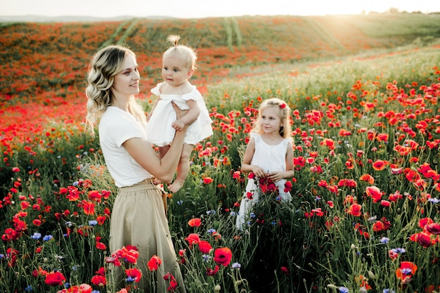 A woman looks at her baby, and woman's elder daughter looks at them